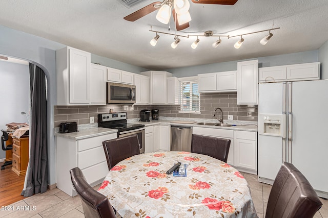 kitchen featuring white cabinets, stainless steel appliances, light tile patterned flooring, and sink