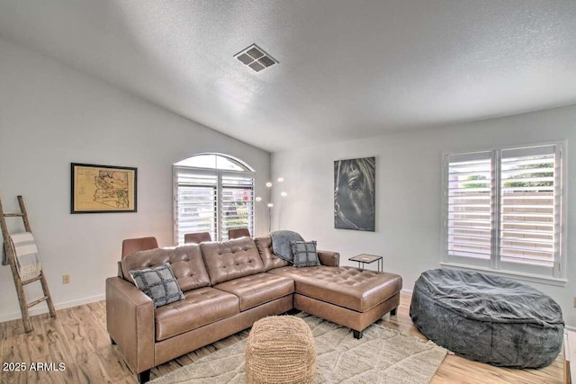 living room featuring a textured ceiling and light wood-type flooring