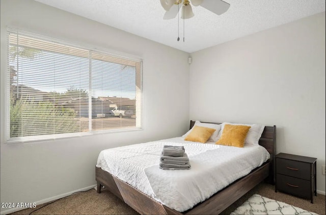 carpeted bedroom featuring a textured ceiling and ceiling fan