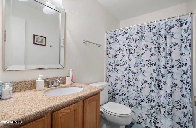 bathroom with curtained shower, vanity, and toilet