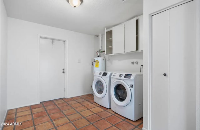 laundry room with water heater, dark tile patterned floors, cabinets, and independent washer and dryer