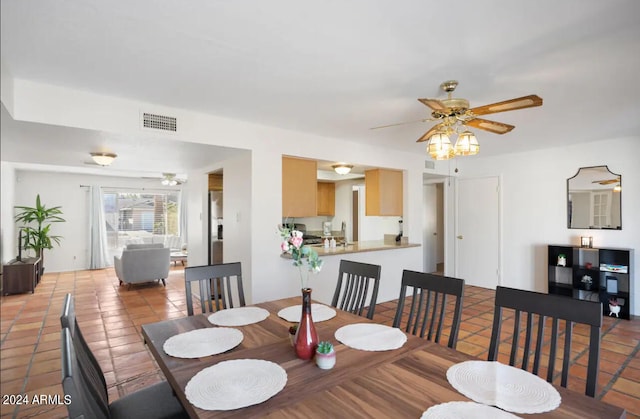 tiled dining area with ceiling fan and sink