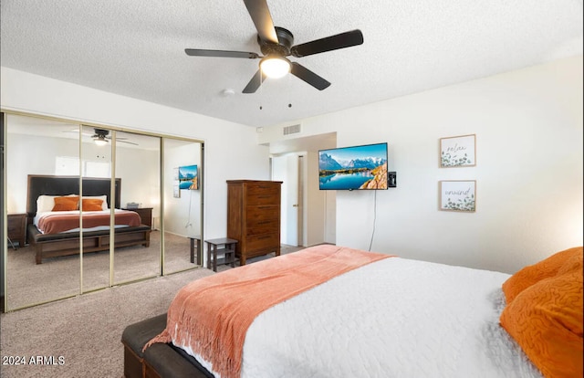 carpeted bedroom with ceiling fan, a textured ceiling, and a closet