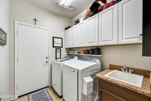 clothes washing area featuring cabinets, sink, light tile patterned floors, and independent washer and dryer