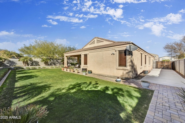 rear view of house featuring a patio area and a lawn