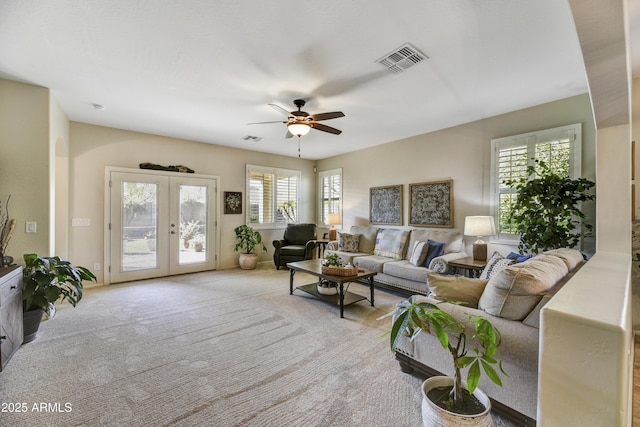 living room with light carpet, ceiling fan, and french doors