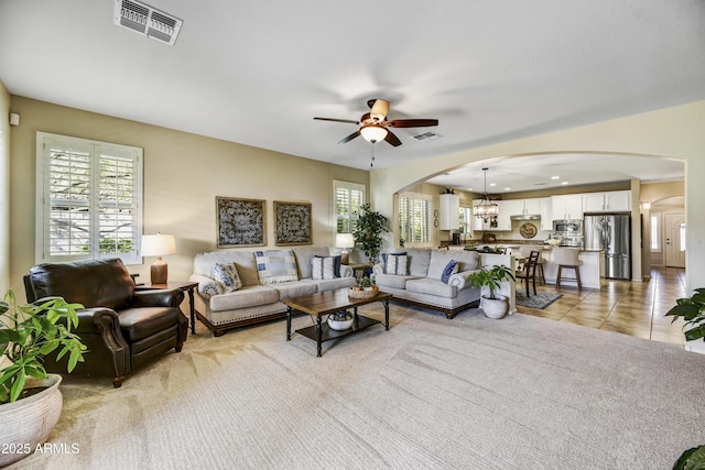 living room featuring light tile patterned flooring, ceiling fan, and a wealth of natural light