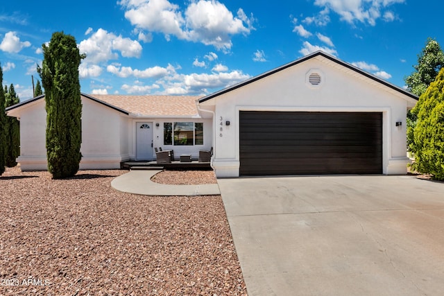 single story home with stucco siding, a garage, and concrete driveway