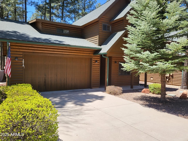 2978 Timberline Rd, Pinetop, AZ 85935 - view of front of house featuring roof with shingles, an attached garage, concrete driveway, and log veneer siding