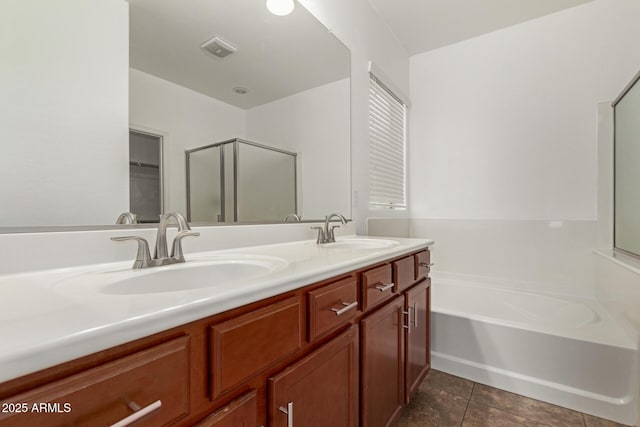 bathroom with a bath, a shower stall, double vanity, and a sink