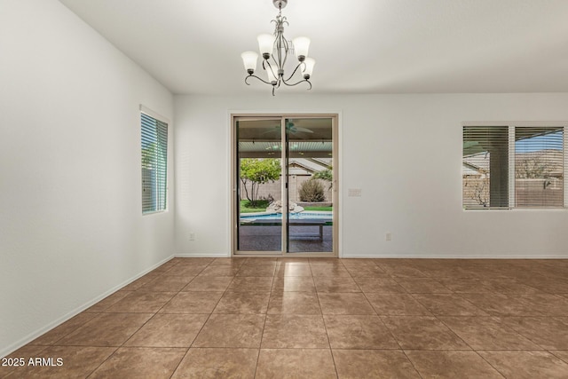 tiled spare room with baseboards and a chandelier