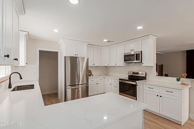33287 N Windmill Run, San Tan Valley, AZ 85144 - kitchen with stainless steel appliances, a peninsula, decorative backsplash, white cabinets, and recessed lighting