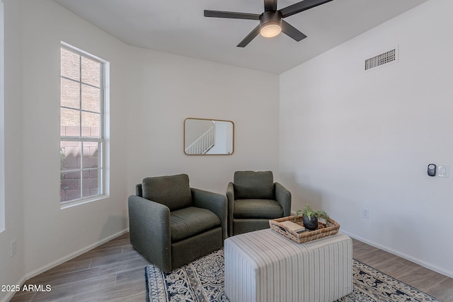 sitting room with baseboards, visible vents, wood finished floors, and a ceiling fan