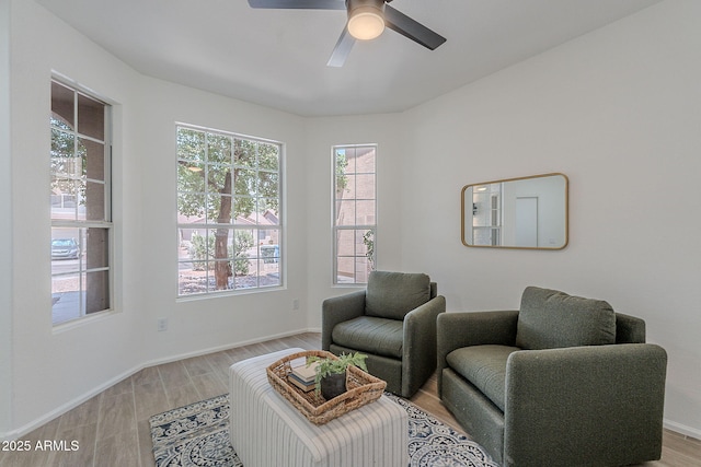 sitting room with light wood-style flooring, baseboards, and ceiling fan