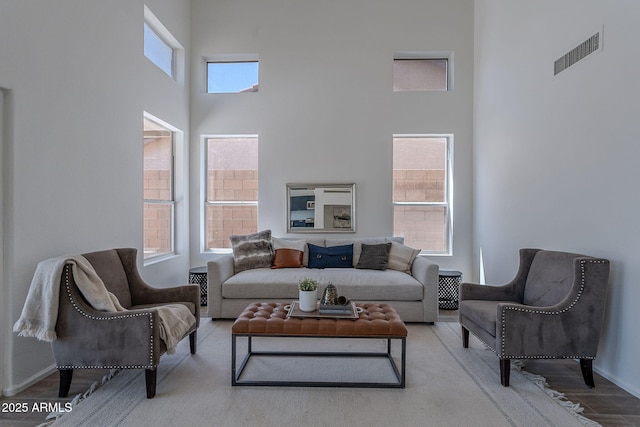 living room featuring visible vents and a high ceiling