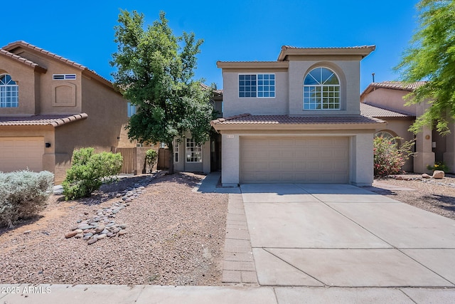 view of front of home with a tile roof, an attached garage, and stucco siding