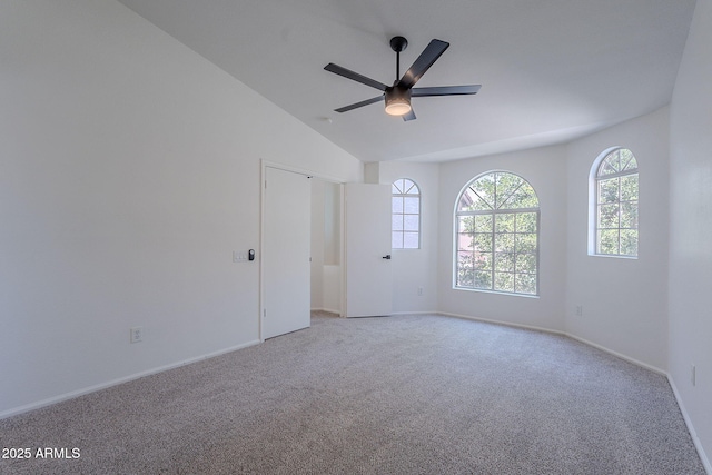 carpeted empty room with vaulted ceiling, baseboards, a ceiling fan, and plenty of natural light