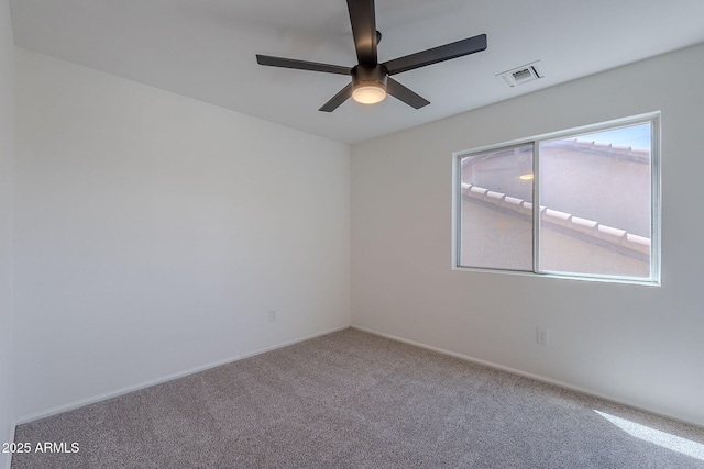 carpeted spare room featuring a ceiling fan, baseboards, and visible vents