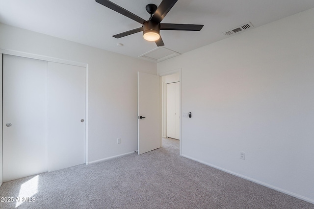 unfurnished bedroom featuring a closet, visible vents, light carpet, a ceiling fan, and baseboards