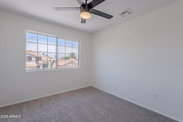 carpeted spare room featuring ceiling fan, baseboards, and visible vents