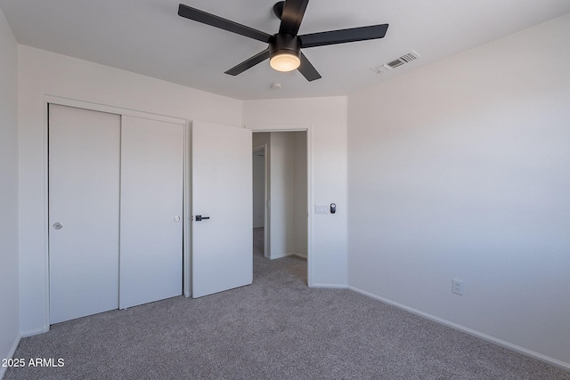 unfurnished bedroom with a closet, baseboards, carpet flooring, ceiling fan, and visible vents