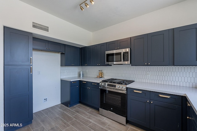kitchen featuring tasteful backsplash, light countertops, visible vents, and appliances with stainless steel finishes
