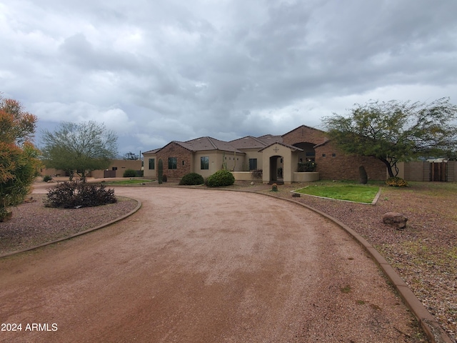 mediterranean / spanish house featuring fence and curved driveway