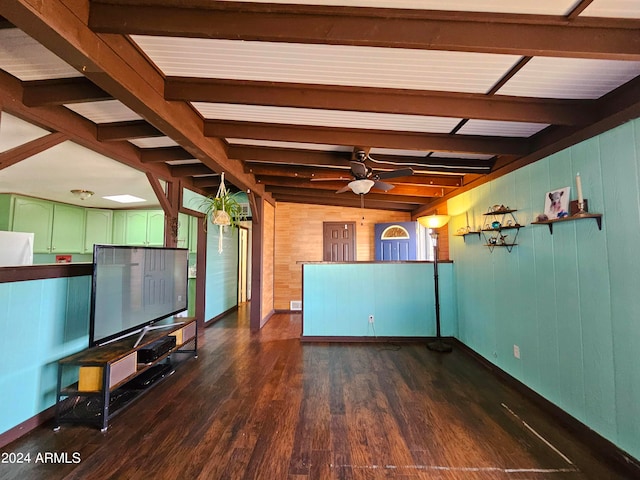 unfurnished living room with vaulted ceiling with beams, dark hardwood / wood-style floors, ceiling fan, and wood walls