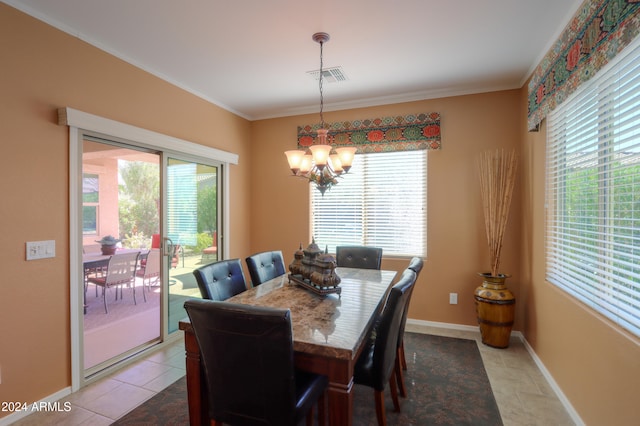 tiled dining area with ornamental molding, a healthy amount of sunlight, and a chandelier