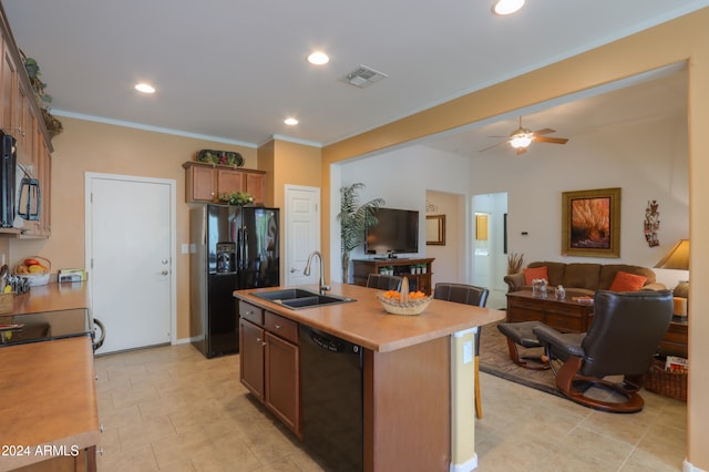 kitchen featuring black appliances, sink, ceiling fan, ornamental molding, and a kitchen island with sink