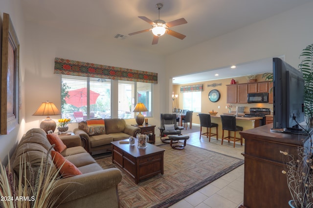 living room featuring a healthy amount of sunlight, light tile patterned flooring, and ceiling fan