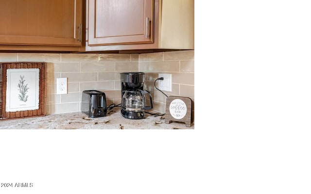 interior details featuring light stone countertops and decorative backsplash