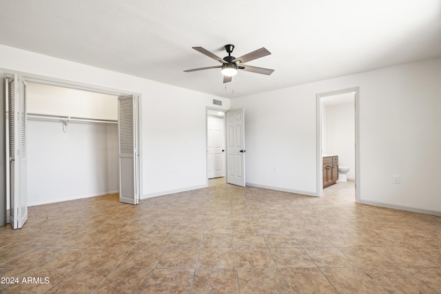 unfurnished bedroom featuring ceiling fan, a closet, and ensuite bathroom