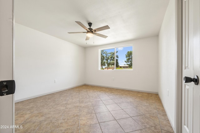 tiled spare room with ceiling fan