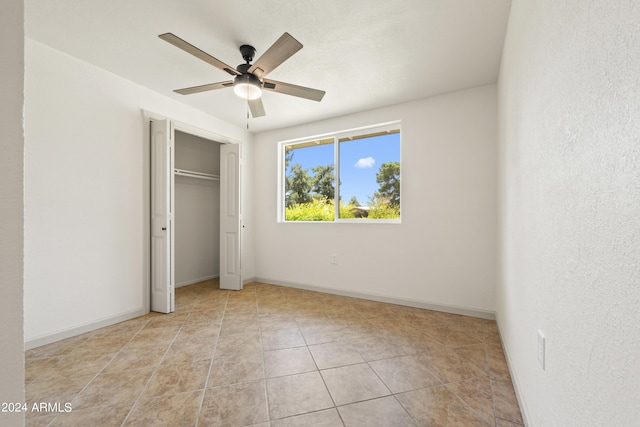 unfurnished bedroom with ceiling fan, light tile patterned floors, and a closet