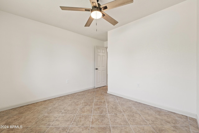 tiled spare room with ceiling fan