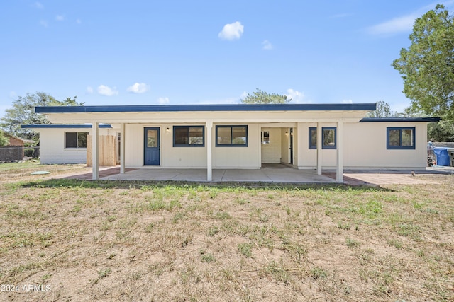 back of property with a patio area and a yard