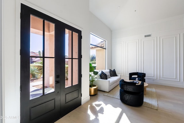 foyer entrance with visible vents, french doors, and wood finished floors