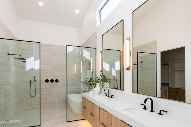 bathroom with a sink, a soaking tub, double vanity, and a walk in shower