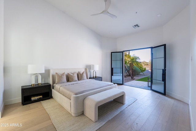 bedroom with access to exterior, visible vents, light wood finished floors, and baseboards