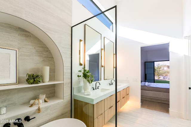 full bath featuring a sink, connected bathroom, and double vanity