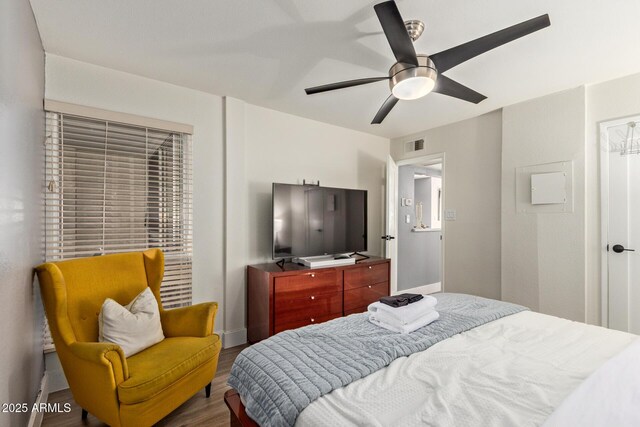 bedroom with wood finished floors, a ceiling fan, and baseboards