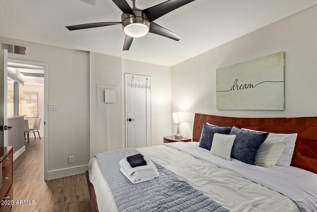 bedroom featuring wood finished floors, ceiling fan, and baseboards