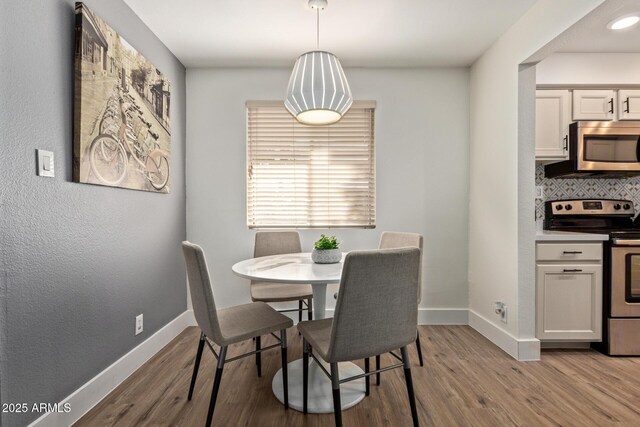 dining area with light wood-style flooring and baseboards