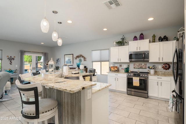 kitchen featuring visible vents, stainless steel appliances, hanging light fixtures, french doors, and white cabinetry