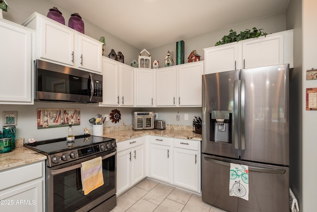 kitchen with light stone counters, white cabinets, and stainless steel appliances