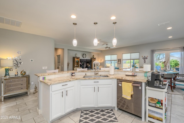 kitchen with a sink, visible vents, light stone countertops, and dishwasher