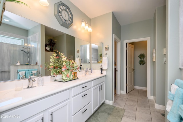 full bath featuring tile patterned flooring, double vanity, baseboards, and a sink