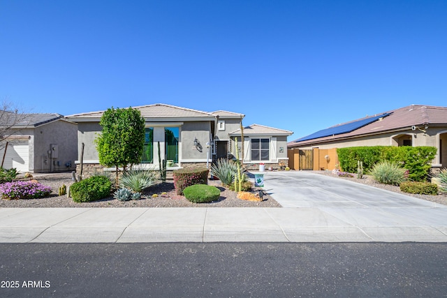 view of front of property featuring stucco siding, stone siding, concrete driveway, and a tiled roof