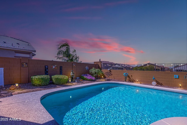 pool at dusk featuring a fenced backyard and a fenced in pool